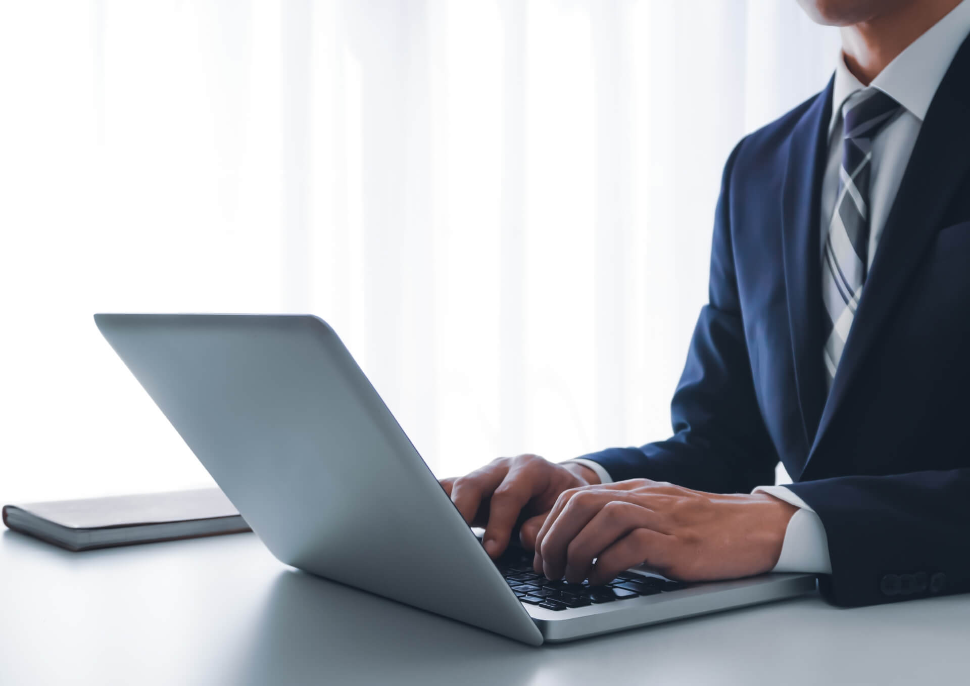 会議中にノートPCを操作する男性