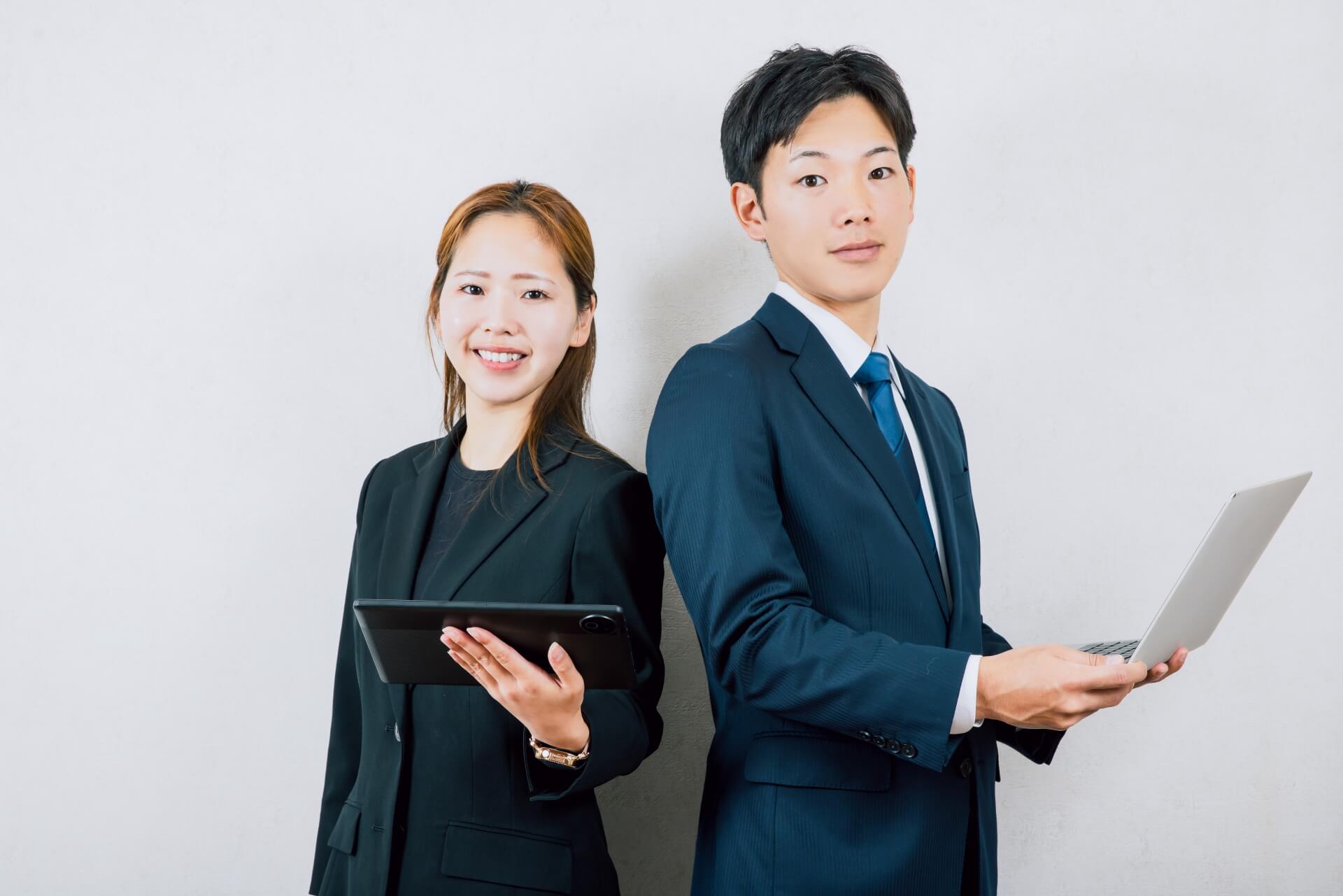 背中合わせに立つスーツの男女