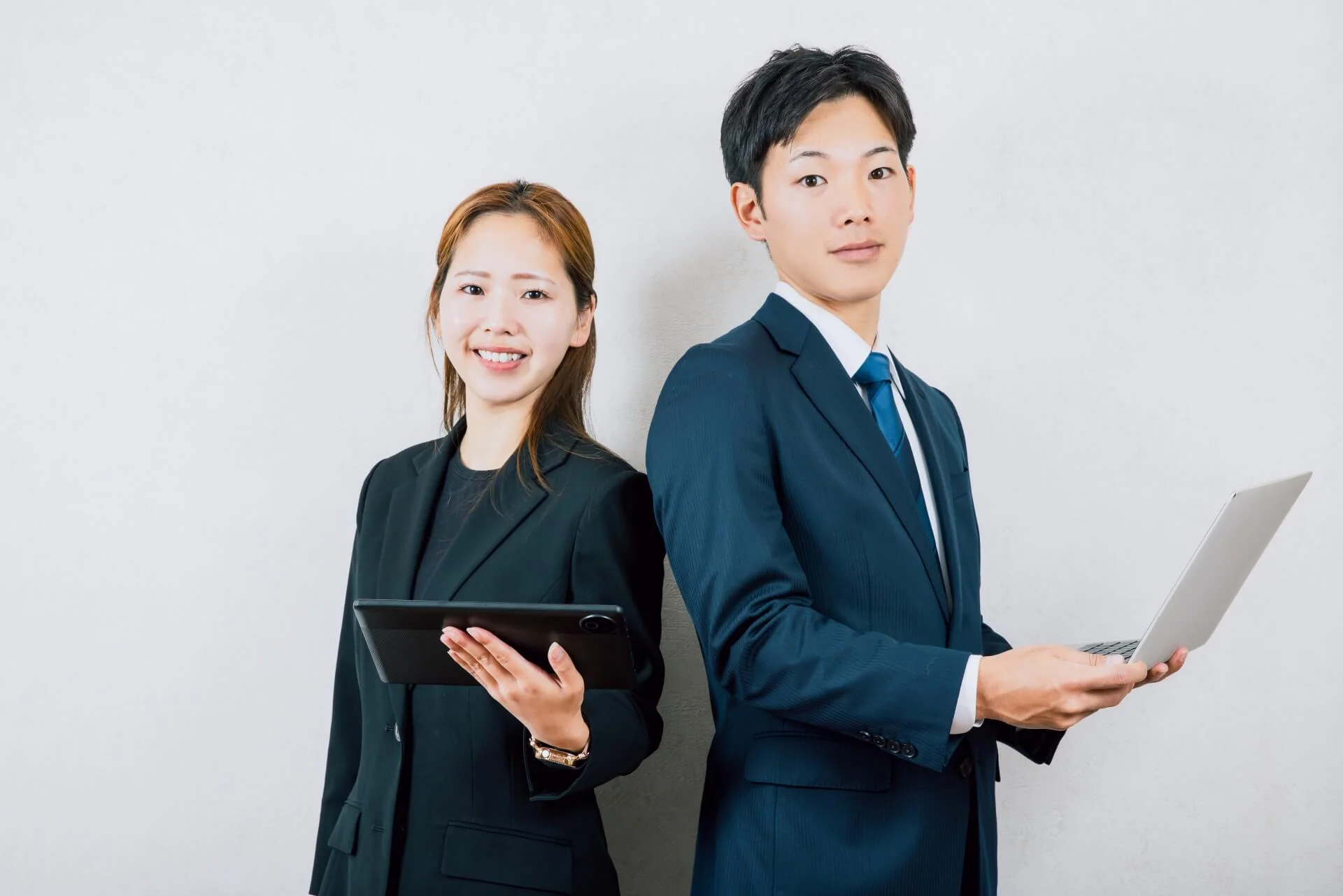 背中合わせに立つスーツの男女