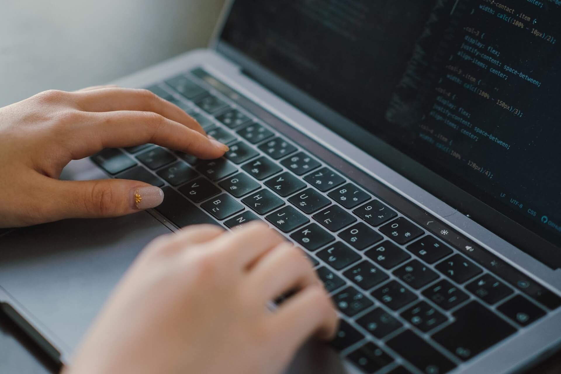 プログラマーがノートPCでコード入力中