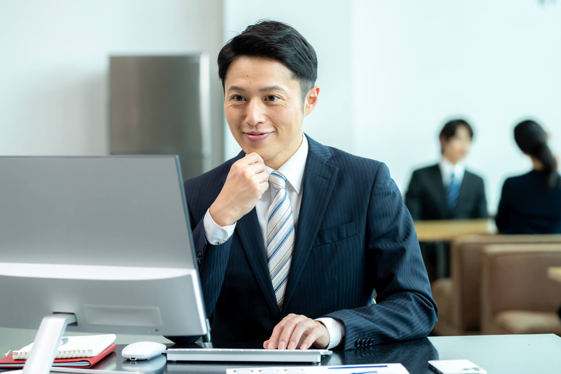デスクで考え込む若いビジネスマン