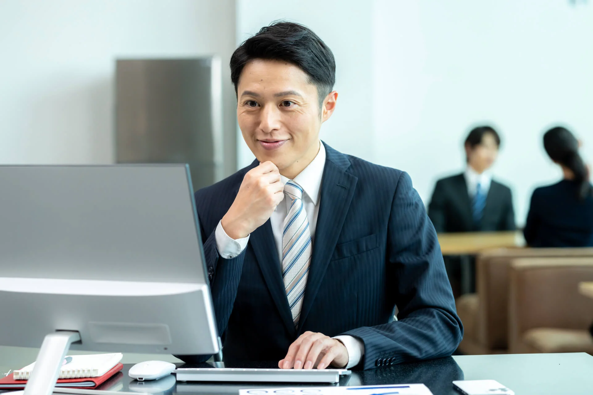 デスクで考え込む若いビジネスマン